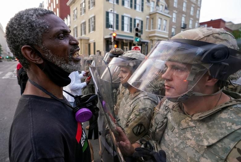 A man yells in the face of a soldier at sunrise outside the White House to protest the death of George Floyd in Washington. REUTERS/Kevin Lamarque    